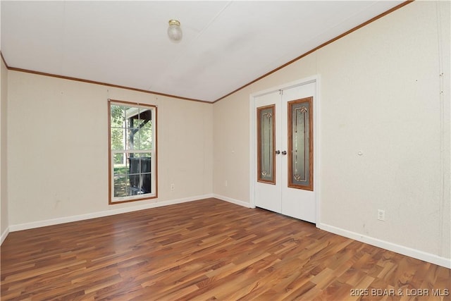 spare room with ornamental molding, wood finished floors, french doors, baseboards, and lofted ceiling