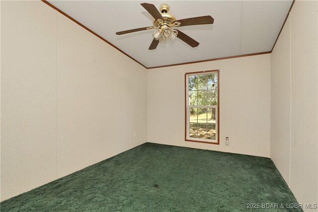 spare room with ceiling fan, crown molding, dark carpet, and vaulted ceiling