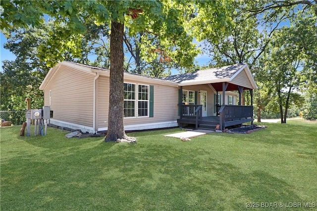 view of front facade with a front lawn and a wooden deck