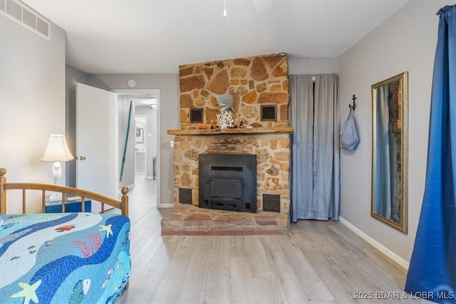 bedroom featuring wood finished floors, visible vents, and baseboards