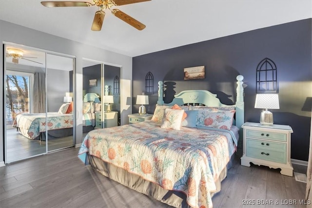 bedroom featuring multiple closets, wood finished floors, and a ceiling fan