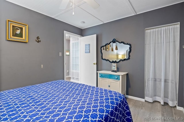 bedroom with light wood-style flooring, a ceiling fan, and baseboards