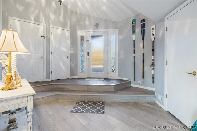 foyer featuring elevator, lofted ceiling, and wood finished floors