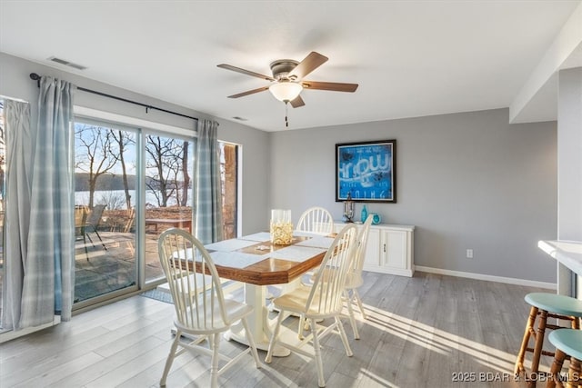 dining area featuring light wood-style flooring, baseboards, visible vents, and ceiling fan