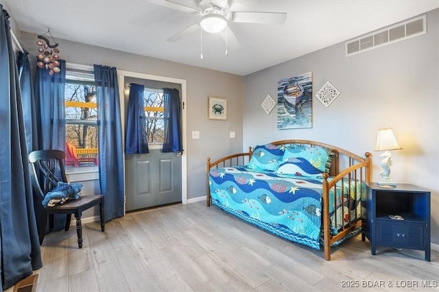 bedroom featuring ceiling fan, visible vents, baseboards, and wood finished floors