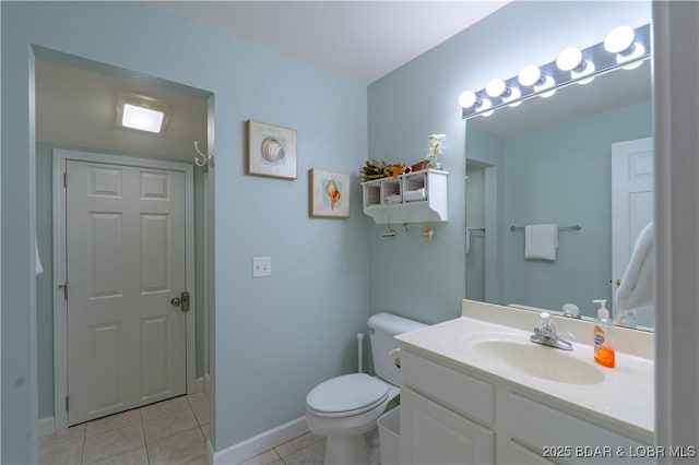 bathroom with baseboards, toilet, vanity, and tile patterned flooring