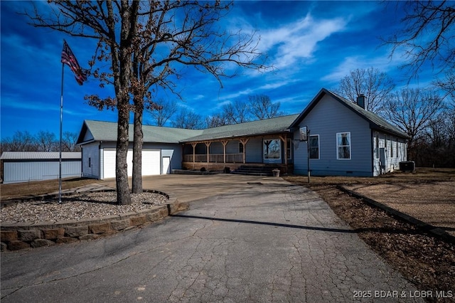 single story home with aphalt driveway, a porch, a chimney, a garage, and crawl space