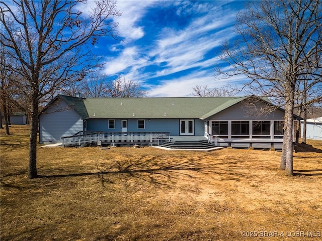 back of property with a wooden deck and a sunroom