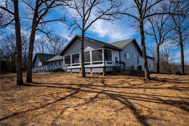 view of front of property featuring central air condition unit and a sunroom