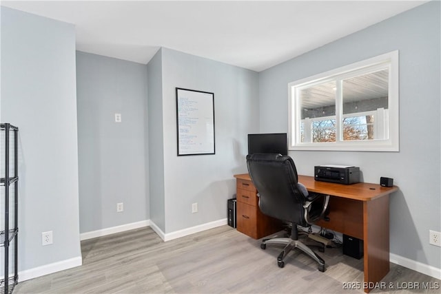 home office with baseboards and light wood-type flooring