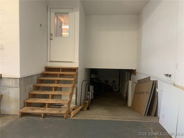 staircase featuring concrete floors