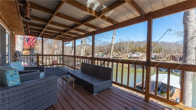 wooden deck featuring an outdoor living space and a water view