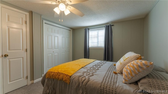 bedroom featuring ceiling fan, a closet, carpet floors, and a textured ceiling