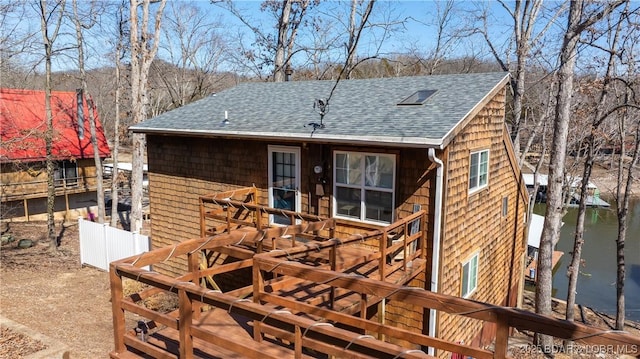 rear view of house featuring a shingled roof