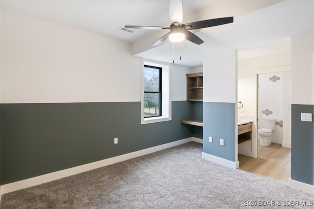 unfurnished bedroom with visible vents, a ceiling fan, ensuite bath, carpet flooring, and baseboards