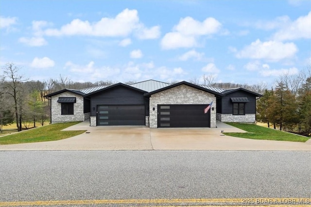 view of front of home with metal roof, driveway, stone siding, an attached garage, and a standing seam roof