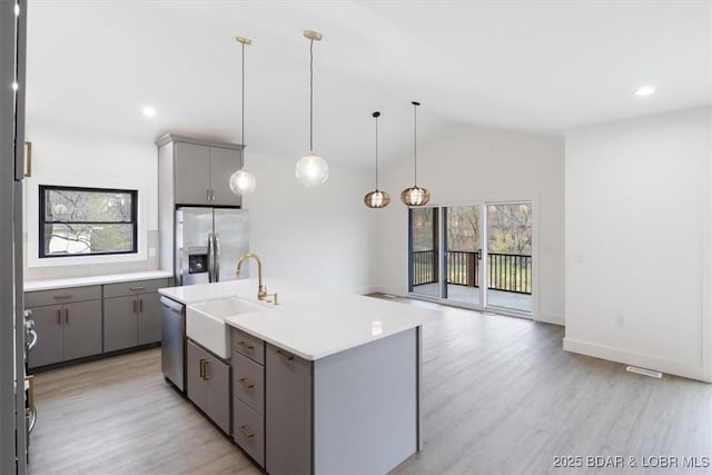 kitchen featuring plenty of natural light, gray cabinets, and appliances with stainless steel finishes