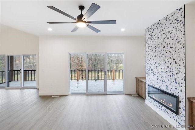 unfurnished living room featuring wood finished floors, recessed lighting, and a fireplace