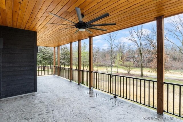 unfurnished sunroom featuring wooden ceiling, plenty of natural light, and a ceiling fan