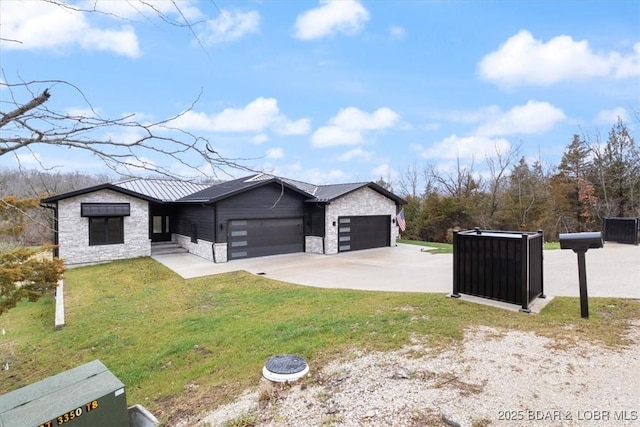 view of front of house with a garage, stone siding, metal roof, and a front lawn