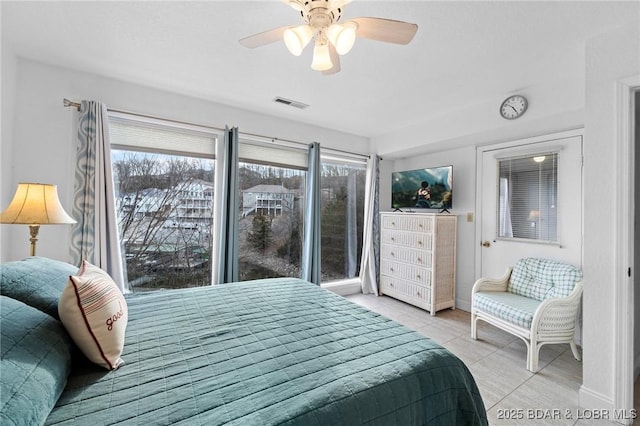 bedroom featuring light tile patterned floors, visible vents, baseboards, and a ceiling fan