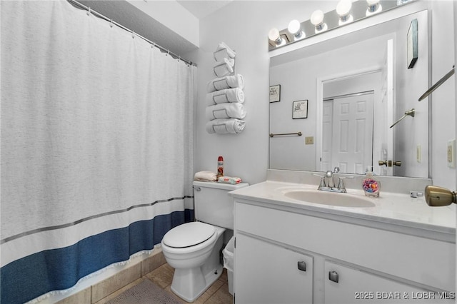 bathroom featuring vanity, tile patterned floors, and toilet