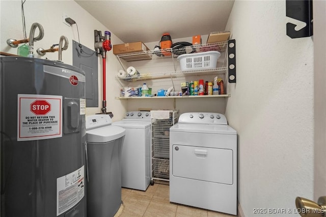 laundry room featuring light tile patterned floors, electric water heater, laundry area, and washing machine and clothes dryer