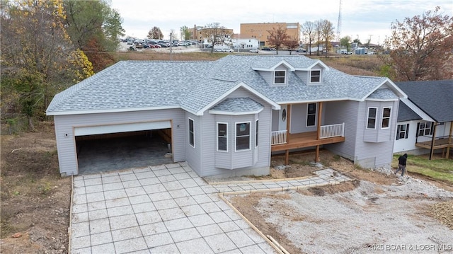 view of front of property featuring decorative driveway, covered porch, a garage, and roof with shingles