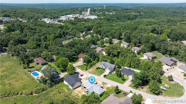 drone / aerial view with a residential view and a wooded view