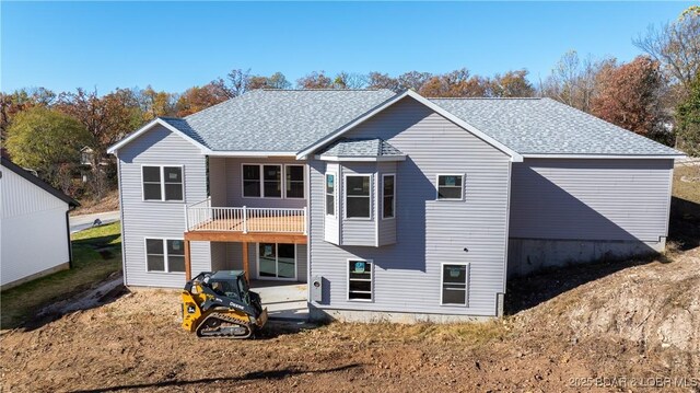 back of house with a patio area and roof with shingles