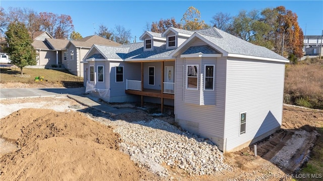 view of front of house with covered porch and a shingled roof