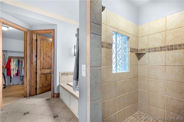 full bathroom featuring tile patterned flooring and tiled shower