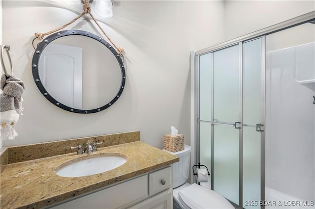 bathroom featuring a shower with door, toilet, and vanity