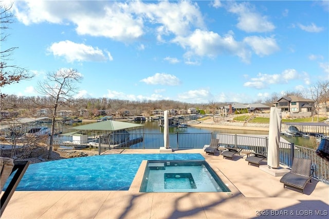 view of pool with a water view, an in ground hot tub, and fence