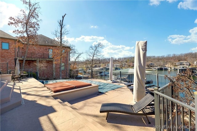 view of patio / terrace with fence and a water view