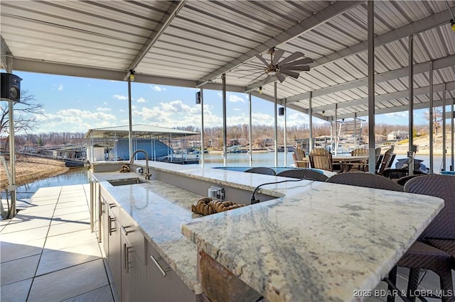 view of patio / terrace with boat lift, ceiling fan, a boat dock, and a sink