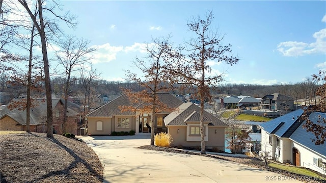 view of front facade featuring a residential view, stucco siding, and driveway