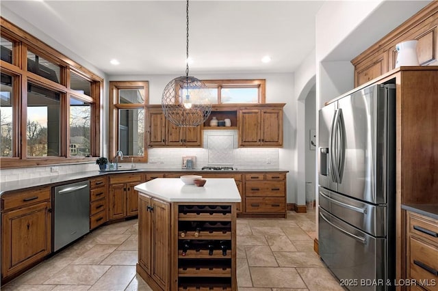 kitchen featuring open shelves, a sink, decorative backsplash, stainless steel appliances, and brown cabinets