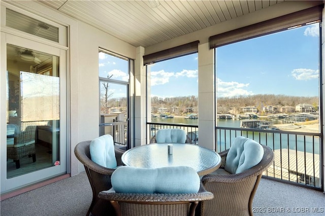 sunroom / solarium featuring wooden ceiling and a water view