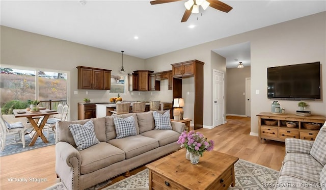 living room featuring recessed lighting, baseboards, a ceiling fan, and light wood finished floors