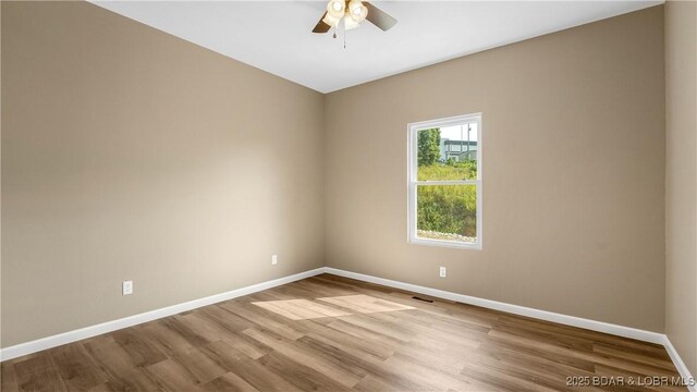 spare room with ceiling fan, baseboards, and wood finished floors