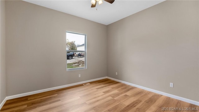 empty room with ceiling fan, visible vents, baseboards, and light wood-style flooring