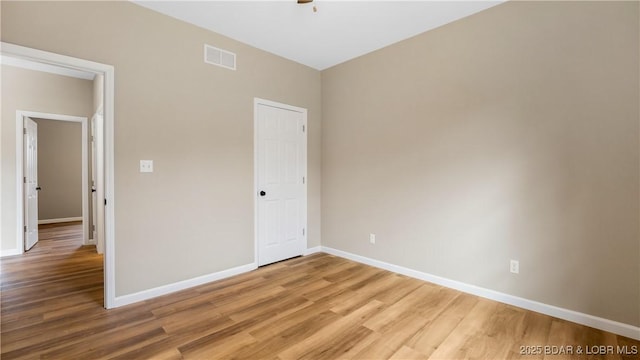 unfurnished bedroom with visible vents, baseboards, and light wood-style floors