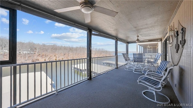 unfurnished sunroom featuring a ceiling fan