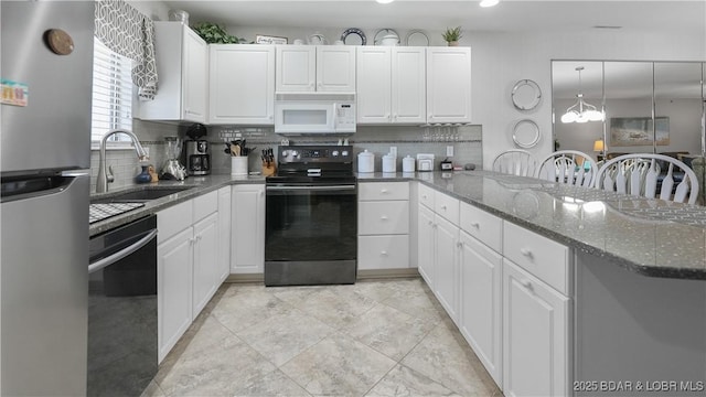 kitchen featuring dishwashing machine, white microwave, freestanding refrigerator, a sink, and black range with electric stovetop