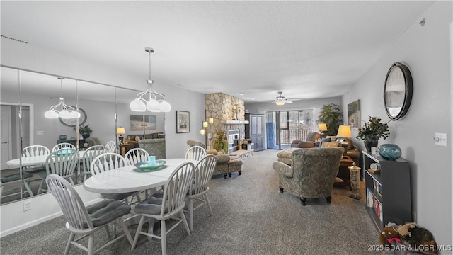 carpeted dining room with a fireplace, visible vents, and ceiling fan