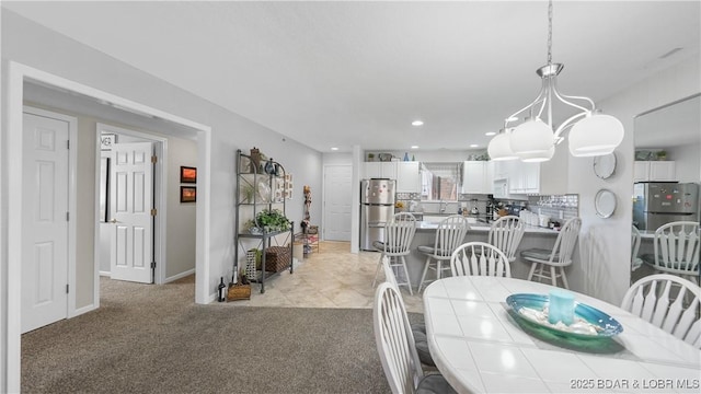 dining area with recessed lighting, light colored carpet, and baseboards