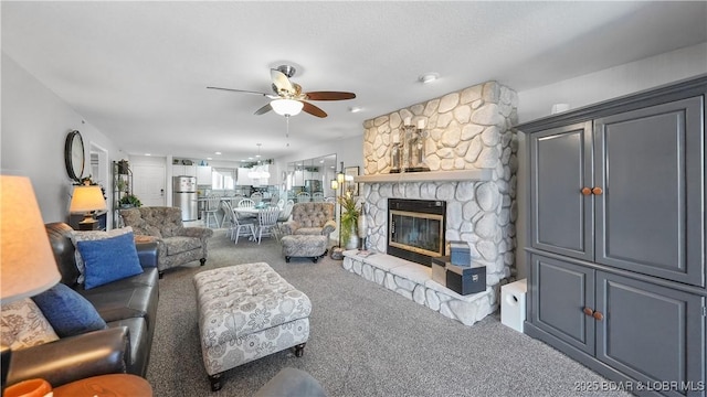 living area featuring a fireplace, ceiling fan, and carpet floors