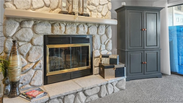 room details with a stone fireplace and carpet flooring