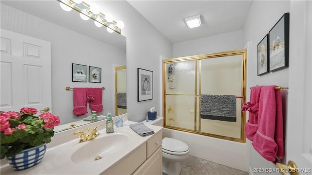 full bathroom featuring vanity, toilet, and shower / bath combination with glass door